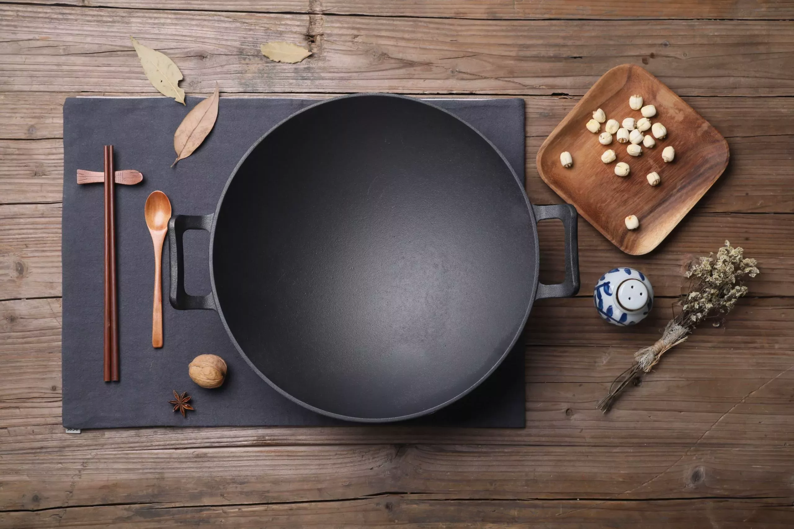 Wok on table with utensils and garnish around
