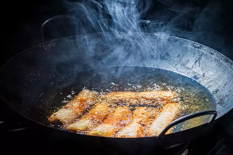 Deep frying spring rolls in a wok